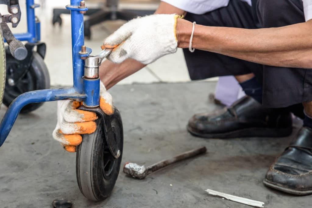 A repair technician working on a wheel chair.